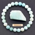 Detailed view of Amazonite beaded bracelet with natural raw gemstone on a grey surface - Amazonite