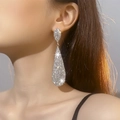 Elegant long teardrop rhinestone dangle earrings in silver finish worn by a model - Shiny Silver