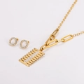 Detail of gold comb-shaped necklace and circular diamond earrings set on white background - Gold