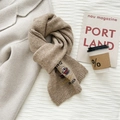 Detail of wool knit scarf featuring cute bear embroidery and stylish letter patterns - Camel