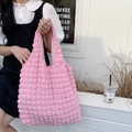 Detailed texture of pink popcorn fabric shoulder bag on a minimalist outdoor bench - Bubble Pink