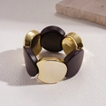 Detail van vintage acryl elastische armband met gouden metalen en bruine geometrische delen - Goud/Bruin