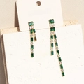 Asymmetrische gouden franje oorbellen met groene en heldere zirkoon op een sieradenkaart - 18K goud / Groen