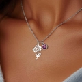 Detail of silver birth flower necklace with purple gemstone on female model's neck - July