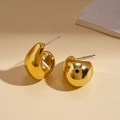 Detailed close-up of polished gold-tone geometric C-shaped stud earrings on beige backdrop - Steel Pin - Gold - Small J-Shape