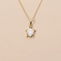 Collana con ciondolo a tartaruga dorata con smalto bianco e cristalli su sfondo beige - Bianco