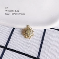 Macro detail of a 13x15mm golden sun pendant with white cubic zirconia inlays - 5# (Sun)