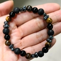 Detailed view of 8mm tiger eye and lava stone beaded bracelet held in hand showing textures - Tiger Eye + Lava + Glossy Stone