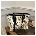 Dettaglio della borsa tote bianca con graffiti e un simpatico ciondolo a forma di orso beige - Con Ciondolo / Nero