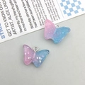 Close-up of glittery pink and blue gradient butterfly resin charms with metal loops - Blue Pink Gradient Resin Butterfly