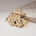 Macro-detail van een gouden onregelmatige bladbroche met getextureerde plooien - Goud