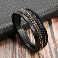 Detailed view of multilayer black leather braided bracelet with gold and silver rivets - Black