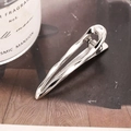 Minimalist silver metal drop-shaped hair clip on dark paper and wooden surface - Silver