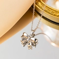 Squisita collana con ciondolo a fiocco d'argento su superficie riflettente con decori eleganti - Color Acciaio