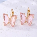 Detalle de elegantes pendientes de mariposa de cristal rosa con marcos dorados - Oro y Rosa