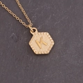 Macro shot of gold hexagon necklace with hammered texture and embossed letter K pendant - Letter K (11#K)