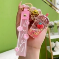 Pink strawberry milk tea keychain with floating liquid sand and a gold keyring - Lidded Milk Tea Cup with Silicone Wristlet