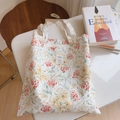 Gros plan détaillé d'un sac cabas en toile à fleurs avec des anses tissées blanches - Branche Fleurie Rouge Orangé