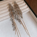 Detail of long tassel earrings with silver leaves and golden chains on a velvet tray - Silver Needle - Silver - Gold