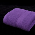 Soft purple pure cotton bath towel featuring geometric jacquard trim on black background - Deep purple