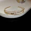 Détail d'un bracelet fleuri doré à double couche sur un plateau en céramique blanche - Or-Fleur à Cinq Pétales Ouverte (31#HB3099)