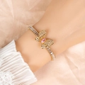 Elegant gold butterfly bracelet with pink gemstone and white zircon stones on silk background - Pink