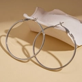 Detailed view of silver hollow geometric hoop earrings on a decorative stone base - Silver (60mm Diameter)