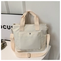 Detail view of large beige oxford tote bag with front pocket and adjustable strap - White