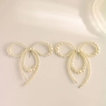 Elegant bow-shaped drop earrings featuring creamy faux pearls with a refined gold post - Silver
