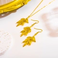 Conjunto elegante de collar y pendientes de hojas doradas sobre fondo vintage retro - Juego / Chapado en Oro de 18K