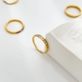 Detailopname van gouden titanium stapelringen met zirkoon en ster op witte steen - US 6 / Halve cirkel diamant