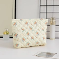 Close-up of quilted floral cosmetic bag featuring a secure top metal zipper closure - Large Capacity / Yellow Base Orange Flower