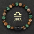 Detail of Libra zodiac bracelet with tiger eye beads on a dark textured background - Libra