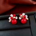 Close-up of 18K gold plated horse-themed red pearl stud earrings on a luxury display box - Red Bead Gold Cluster Earrings