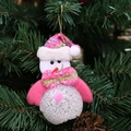 Rosa und weißer Schneemann-Anhänger mit Plüschmütze am grünen Weihnachtsbaum - Schneemann