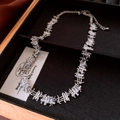 Macro detail of silver-tone link necklace with rectangular zircons in a black jewelry box - Necklace - Silver