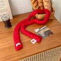 Narrow red knitted scarf with Vegetable label on warm wood background - Red