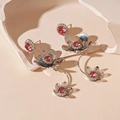 Détail de boucles d'oreilles fleur argentées avec zircons roses sur support en pierre - Style de Gland de Fleur Rouge à Tige en Argent / Rouge