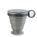 Tazza da caffè pieghevole in silicone grigio con coperchio nero e cinturino su sfondo bianco - Confezione in busta / Grigio