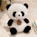 Plush panda doll in a sitting pose with soft fur and a decorative brown leather tag - Sitting Panda