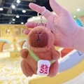Brown Capybara plush keychain wearing green straps and a small white lucky bag accessory - Dark Brown Red Fortune + Silver Clip