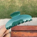 Detail of a large green glitter hair claw clip held outdoors under natural light - Seven Teeth Claw / Deep Green Glitter