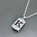 Macro shot of silver hollow letter K dog tag pendant on a titanium steel necklace chain - Letter K