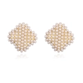 Macro shot of gold-plated rhombus stud earrings set with small white pearls - Gold Rhombus