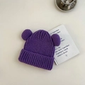 Detalle de un gorro de punto morado para niños con dos pompones y textura gruesa - 3-8 Años / Morado