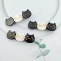 Close-up of cute black and white acetate cat hair clips with elegant gold detailing - Two-Color Cat