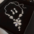 Macro view of crystal floral necklace and teardrop earrings in a black gift box - Large Flower Shape Pendant Set / Silver