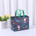 Blue non-woven Christmas gift bag with Santa Claus patterns and green handles - Christmas New Blue