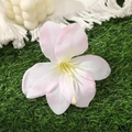 Nahaufnahme einer realistischen rosa Lilie Haarklammer auf grünem Gras für das Haar - Hellrosa