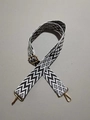 Detail van verstelbare zwart-witte geweven riem met gouden metalen musketonhaken - Wit